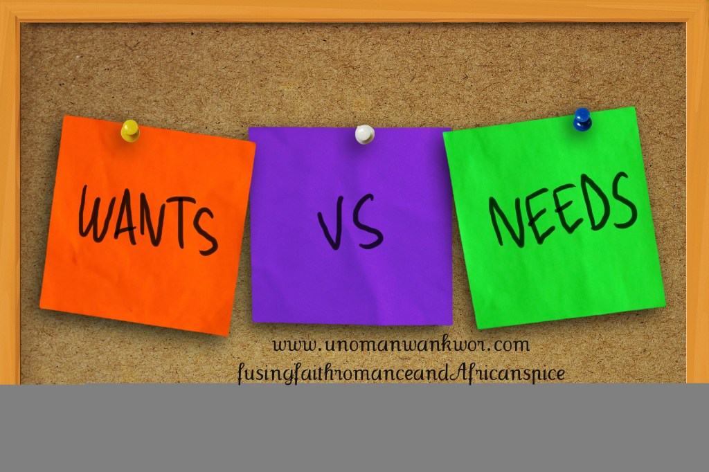 The words wants vs needs written on sticky colored paper over cork board